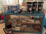 This show case contains, baseball costume jewelry, vintage pins. On the top wonderful vintage NFL drinking glasses, a vintage Dallas Cowboys Bobble head, Pan Am airplanes