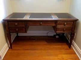 High-quality desk by Sligh.  Three tooled leather inlays, 5 drawers, brass drawer pulls.  One spot of damage to leather.