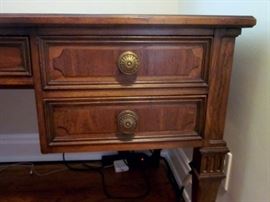 High-quality desk by Sligh.  Three tooled leather inlays, 5 drawers, brass drawer pulls.  One spot of damage to leather.
