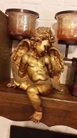 Gold painted angel mounted on the fireplace mantel