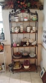 bakers rack with assortment of dishes and cups, and bowls, and cooking wares 