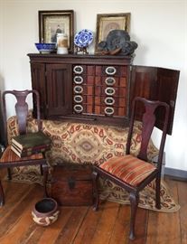 Old photos in antique wood frames, cotton chenille rug (4'7" x 6'7"), antique Japanese (rosewood?) box, old pottery pieces a pair of chairs and an Ambergs Peerless Letter File (1880's) wood cabinet with alphabetized drawers. On top right is an old Japanese item believed to be a Temple roof cap with a character that represents water.