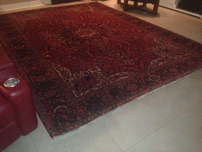 Rectangular, polychromatic,
geometric and floral patterned, wool
Persian rug with shades of red,
orange, green, blue, black and white.
The piece is 150 inches long and 118
inches wide and has roughly 140
knots per square inch.