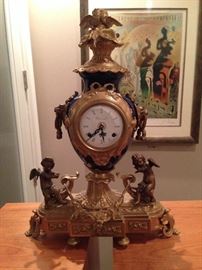 A Louis XVI-style, mantle clock
made of brass and cobalt
porcelain with cherubs and
floral motifs with a white
porcelain face with black
Roman numerals and black
hour and minutes hands. The
piece is 21 inches high, 14
inches wide and 5 inches deep
and weighs 25 pounds or more.