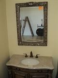 Bathroom display includes mirror, cabinet, fixtures.