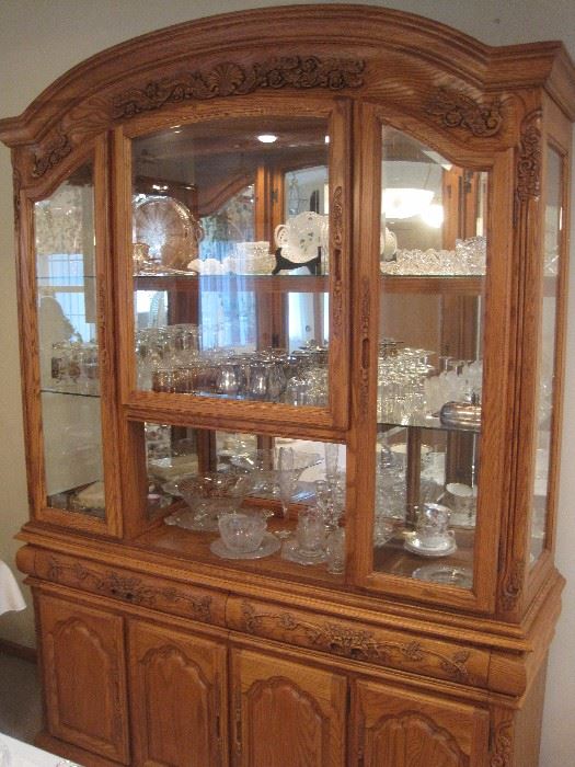 Carved display cabinet with light. Lots of crystal and china.