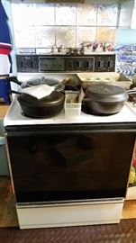 Iron Pans &  Close up of "Whirlpool" Electric 4-Burner Stove/Oven with pullout storage drawer below.