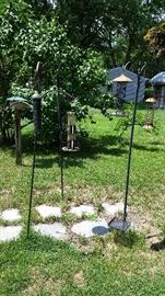 Several Shepard hooks and bird feeders 