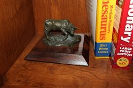 Bronze bull on wooden plaque.