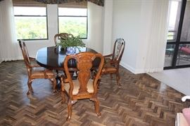 Light walnut oval table with 4 arm chairs.