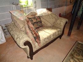 Vintage love seat with hand carved wood trim and framing.