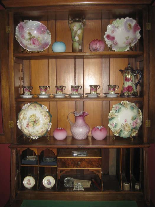 Porcelain plates, demitasse set, satin glass pitcher/bowls on  shelves on antique secretary/bookcase