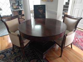 Beautiful pair of vintage French silk/leather covered bergere chairs, flanking a round-topped empire table.