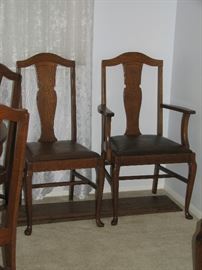 Older wooden chairs, one captain chair