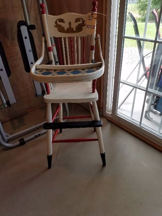 Antique high chair w/history on under seat.
