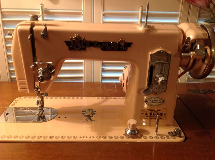 1950's pink Atlas sewing machine, attachments, and solid wood cabinet