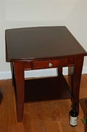 Cherry finish end table, stain nickel hardware on the drawer and a display shelf below.  There is a matching coffee table available as well.