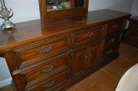 Solid wood bedroom dresser with an attached mirror.  There is also a nightstand to match and a headboard as well. 