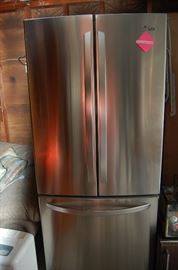 Less than 5 years old, this stainless steel LG refrigerator features french doors.  There is an ice maker located in the freezer section on the bottom.