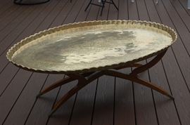 A vintage mid-century brass table that sits on the wooden stand.  It may be removed and used as a wall hanging as well. 