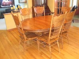 Oval pedestal table with claw feet with 6 pressed back chairs.