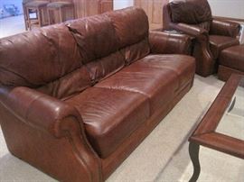 Leather sofa with matching armchair and ottoman.Leather framed coffee table.