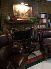Framed art with light; fireplace screen; small cross legged bench; pair of leather recliners