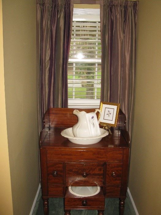 Regency mahogany wash stand with slop pot drawer, turned ring and tapering cylinder legs to arrow terminals. turned classical knobs, high back splash.Circa: 1820