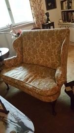 Upholstered wing back love seat with claw feet