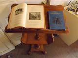 Book lectern, with copies of "Tennyson's Poems, Illustrated, 1886 copyright, and "Little Lord Fauntleroy illustrated by Mary Burnett, 1891 copyright.
