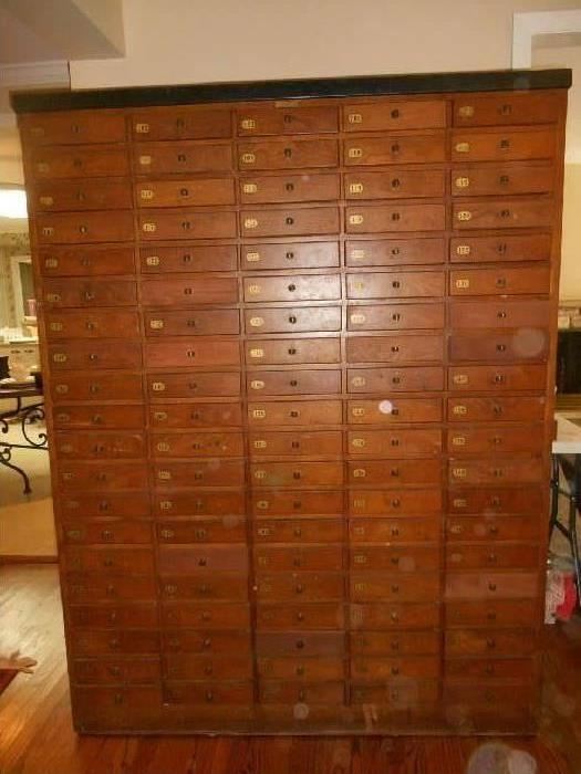 Family Room:  An antique 100-drawer cabinet.  Drawers are numbered 101-200 (left to right).  It measures 74" tall x 56" wide x 18" deep.  All but a couple of drawers are original and of dovetail construction.  Each drawer measures 8-1/2" wide x 13-l/2" deep.   This is a very "statement" piece and could be used for apothecary purposes, hardware, crafts, herbs and teas, whatever many items you have to sort!