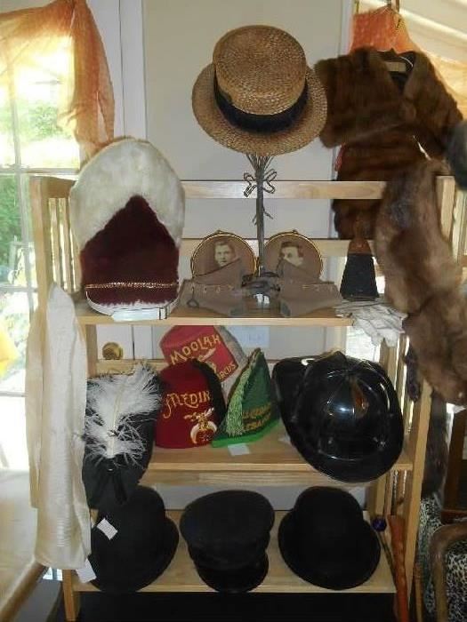 Family Room-SMALLS Area:  Just some of the many men's hats and more:  majorette hat; straw hat; spats; vintage photos; white gloves; MOOLAH cap; fireman's hat; derby hats.  Also shown on the right is a vintage mink collar with matching muff (SOLD AS A SET) as well as a vintage mink wrap (heads attached).