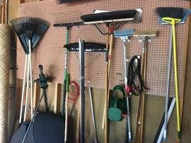 Assortment of lawn tools: rakes, brooms, shovels, scrubbers