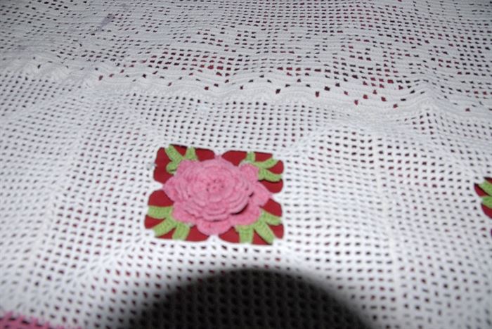 A close up of one of the flowers. The red background color is just the color of the bedspread underneath. 
