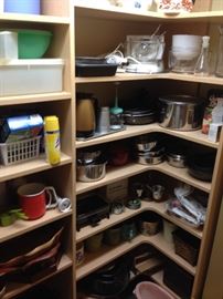 Some nice pots and pans, enamel, cast iron, kitchen gadgets in a well-stocked pantry