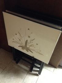 Two sets of TV trays, these with a laminate surface and a vintage set with tole style painting