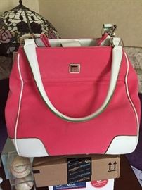 Tote bag pink and white. Looks to be used only a few times still with green edge covering to keep the product from scratching. Excellent condition. Includes longer strap and inside clip on plastic storage. $30