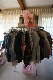 One of three commercial clothing racks fully loaded