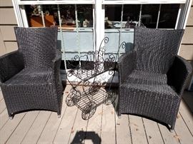 Two outdoor wicker armchairs and a flower cart