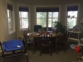 A third breakfast room table and chairs, exercise equipment, and high chair.