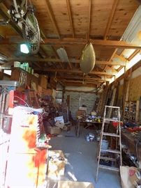 large garage , filled with many carpenters tools, ropes, chains, copper wire, cabinets are full. Saddle, bicycles, kayak, ladders, many tools. Old wood cabinets