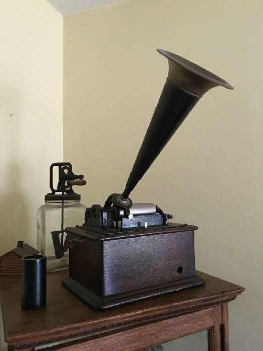 Antique Edison phonograph in oak cabinet.  Black and brass horn -- includes case cover and wax cylinder.  Edison label in good condition, legible, but does show some wear.