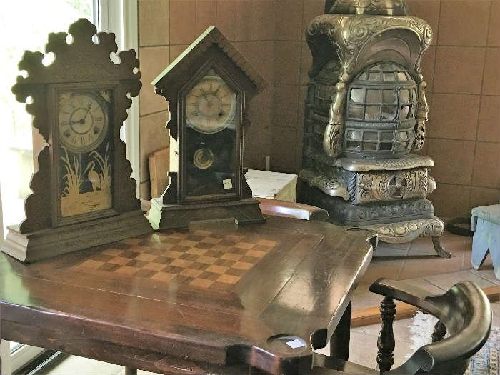 Square walnut game table with 4 matching chairs -- shows wear and chairs need refinishing. Antique clocks