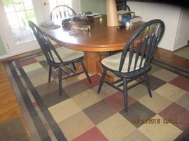 Solid oak pedestal kitchen table with four black chairs