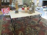 Cultured marble top coffee table sits on cranberry, green, beige woolen rug.