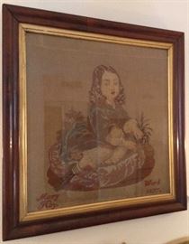Framed needlepoint behind glass, dated 1877.