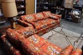 Upholstered couch and loveseat, brass and glass coffee table, Hollywood Regency end tables, novelty lamp