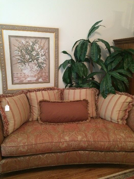 Extra nice sofa and decorative pillows; one of several framed art selections; large artificial plant