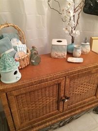 Rattan cabinet and shell vanity decor; artificial orchard plant 