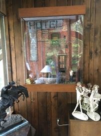 Ok. You can't see this too well in the photos. It is a diorama on a street in front of a hotel maybe in New Orleans? It is behind plexiglass and quite large in its wooden frame. The windows light up as do the little street lights, etc.